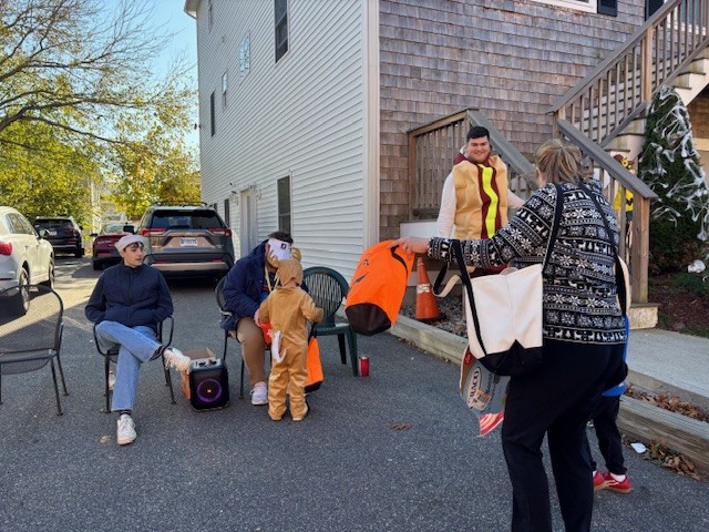 Children trick-or-treating and being given candy by students