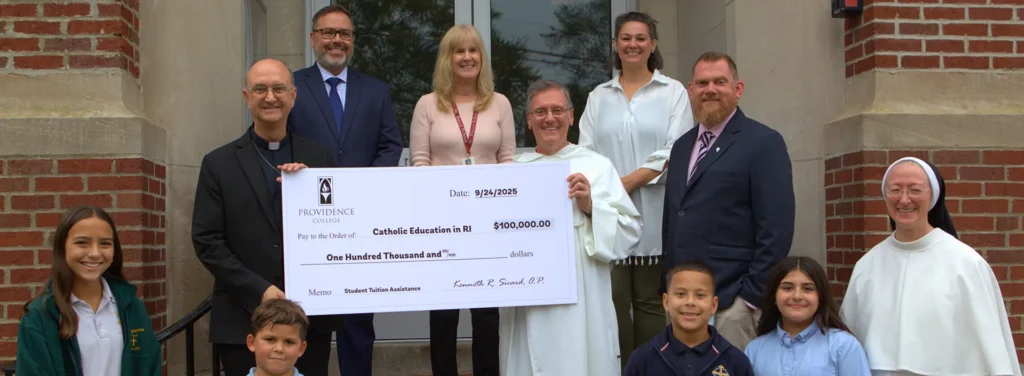 father Sicard delivering a check for $100,000 to Catholic Education in RI